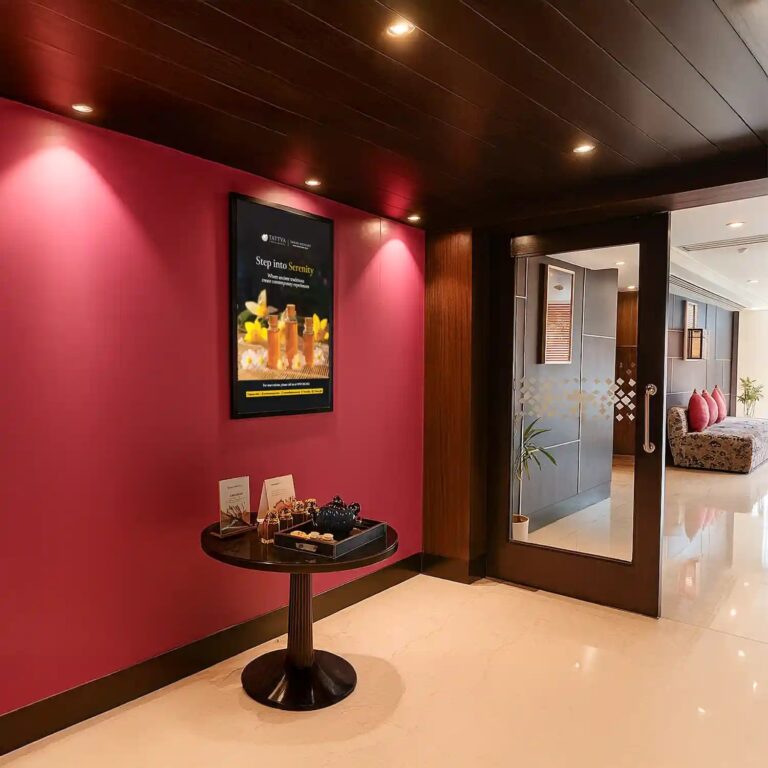 Entrance hallway of Tattva Wellness Spa, Grand Mercure Agra with bright décor, welcome table, and spa poster.