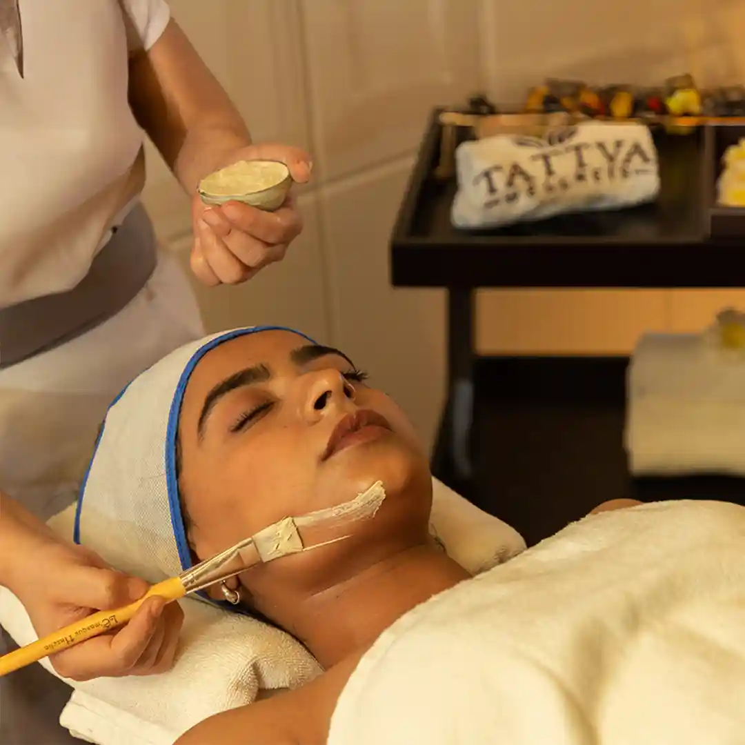 Spa therapist at Tattva Wellness Spa applying a rejuvenating facial mask, promoting healthy, glowing, and refreshed skin.