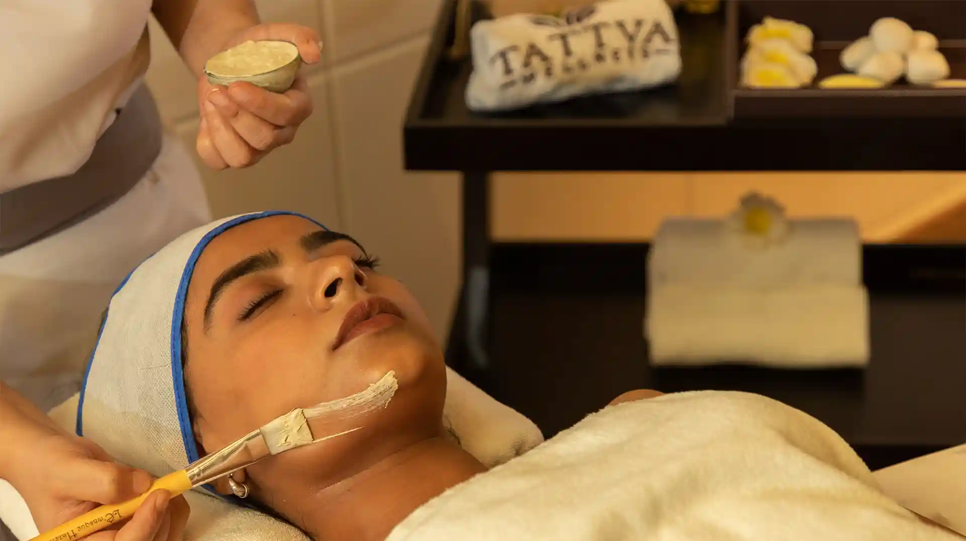 Spa therapist at Tattva Wellness Spa applying a rejuvenating facial mask, promoting healthy, glowing, and refreshed skin.