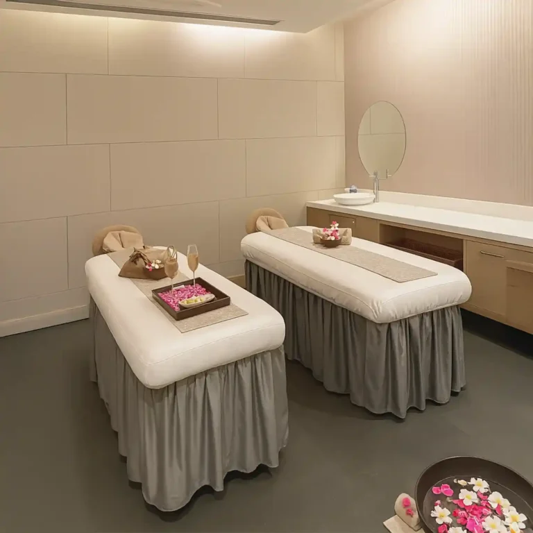 Elegant couple massage room with twin beds and flower arrangements at Tattva Spa Radisson Udyog Vihar Gurgaon.