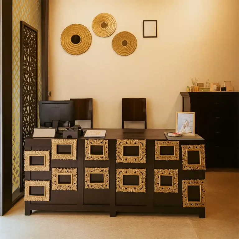 Elegant reception desk with golden décor at Tattva Wellness Spa, Courtyard By Marriott, Gurugram.