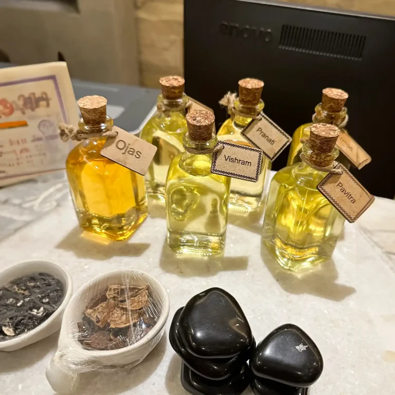 Ayurvedic massage oils and wellness ingredients at Tattva Wellness Spa, labeled Ojas, Vishram, Pranati, and Pavitra, used for holistic therapies.