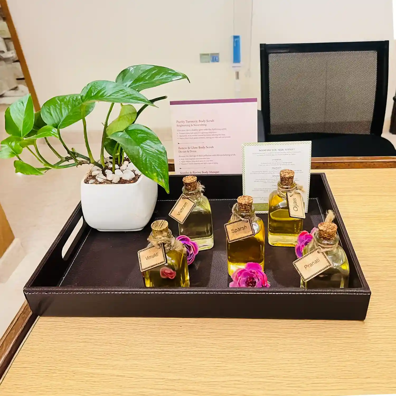 Tray with essential massage oils and plant decor at Tattva Wellness Spa, Lemon Tree Ulsoor, Bengaluru