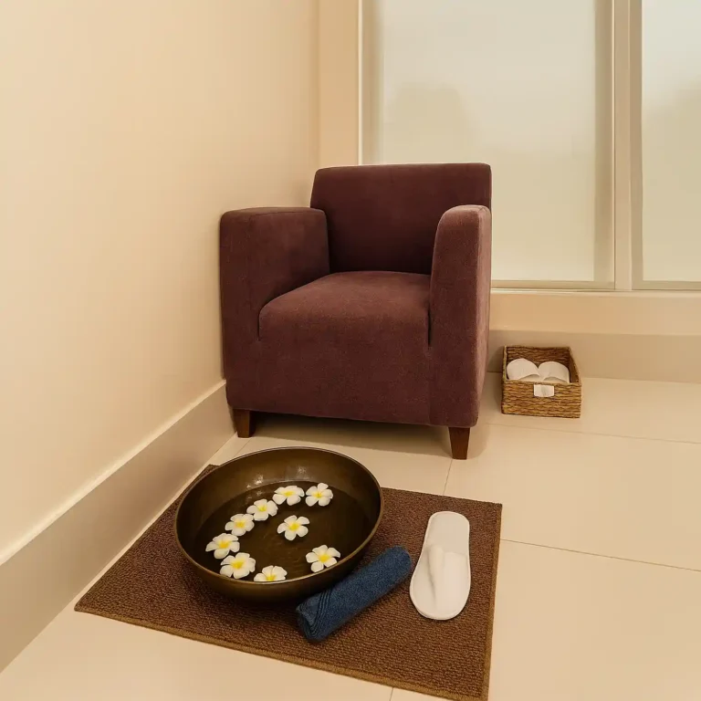 Foot spa setup at Too Yoo Spa & Salon with armchair, flower bowl, towel, slippers, and serene minimal décor.