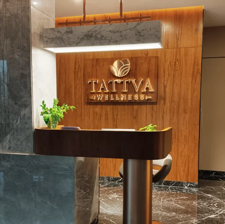 Elegant reception area at Tattva Wellness Spa with modern wooden interiors, warm lighting, and a welcoming ambiance for guests.