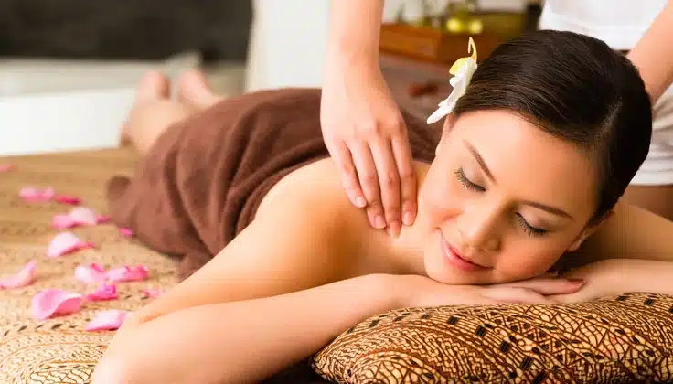Woman receiving a relaxing Full Body Massage focused on the shoulders and upper back at a spa.