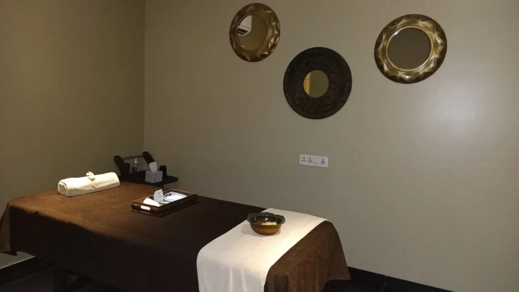 Single spa therapy room at Tattva Wellness Spa with warm lighting, elegant interiors, and a neatly arranged massage bed for relaxation and rejuvenation complimenting it as one of the best spa in pune.