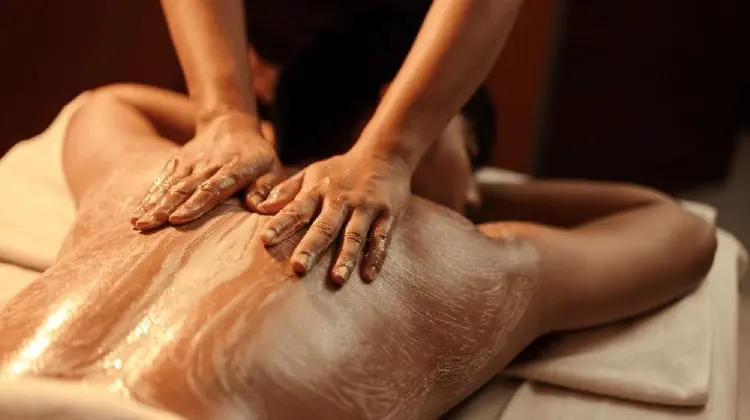a person receiving a body polishing scrub at tattva spa along with back massage