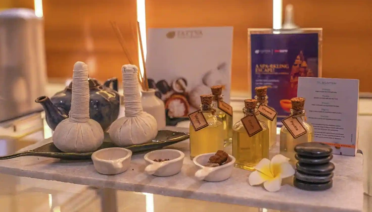 Spa oils, herbal potlis, and hot stones displayed for Tattva Serenity Membership therapies.