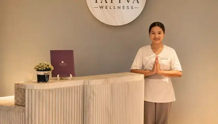Tattva Wellness Spa therapist welcoming guests at the reception desk.