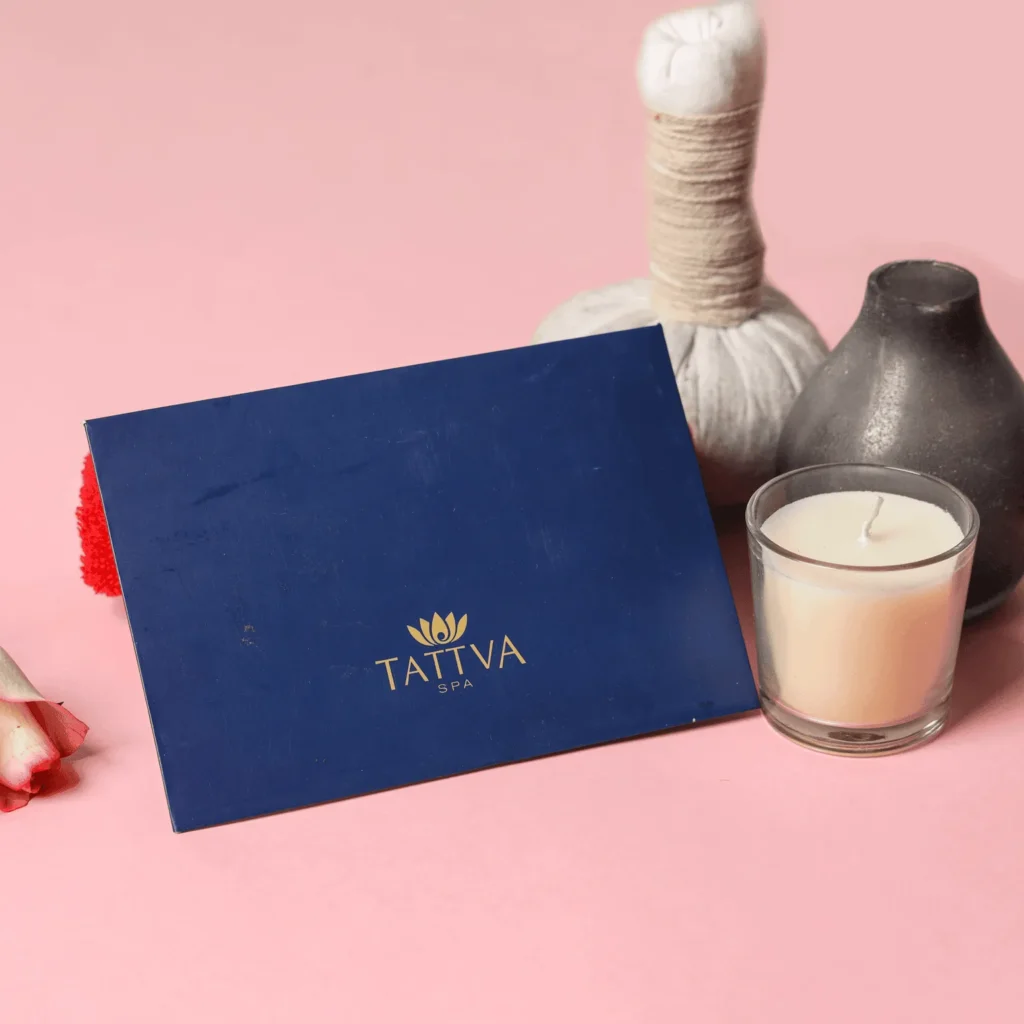 Blue Tattva spa gift card placed on pink background with candle and potli massage potli which makes it Best Diwali Gifts for Employees