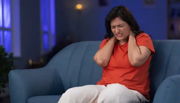 Woman showing symptoms of frequent body aches indicating need for relaxation or massage therapy