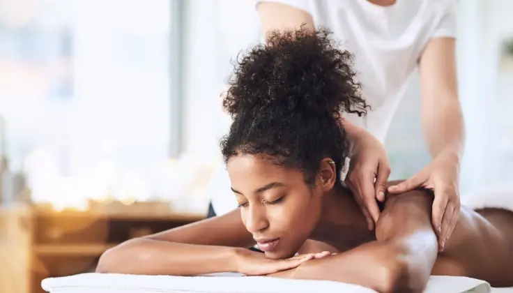 A woman experiencing a Swedish massage that soothes winter-stressed muscles, relaxes the body, and revitalizes energy in a serene spa setting.