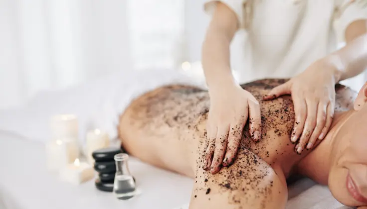 “Therapist performing a body scrub treatment on a client at Tattva Spa”