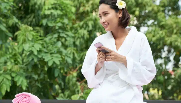 Varsha Ritucharya by Tattva – woman in a spa robe relaxing outdoors, representing massage and monsoon wellness care.