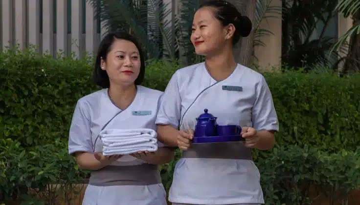 Varsha Ritucharya by Tattva – two spa therapists holding fresh towels and a wellness tea tray, representing hygienic monsoon massage care.