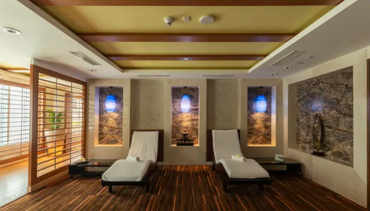 Relaxation lounge at Tattva Wellness Spa with two comfortable loungers and warm interiors.