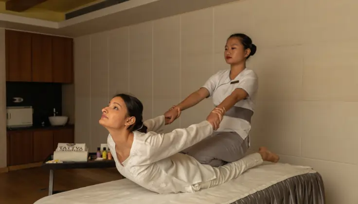 Therapist assisting a guest with a Thai stretching massage at Tattva Wellness Spa.