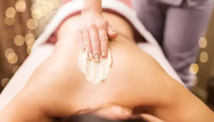 Guest receiving a nourishing body cream treatment for soft and moisturised skin.
