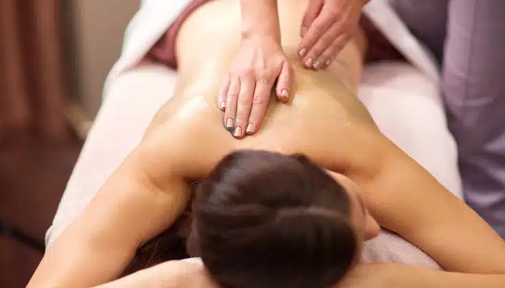 Guest receiving back massage therapy for relaxation and muscle tension relief.