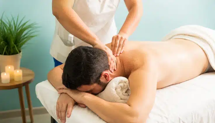 Guest receiving massage therapy to ease neck and shoulder tension and support relaxation.