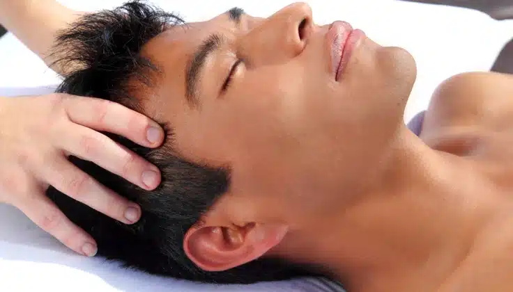 Man receiving a relaxing Indian head massage to ease head and neck tension.