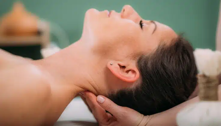 Woman receiving a gentle neck massage to ease neck and shoulder tension.