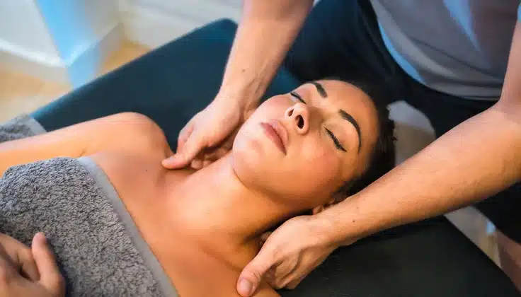 Woman receiving a neck and shoulder massage to relieve muscle tension.