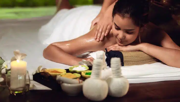Guest receiving an Ayurvedic massage with herbal potlis for an Abhyanga vs Potli Massage therapy comparison.