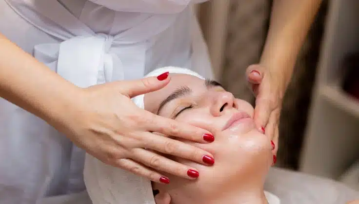 Woman receiving a gentle facial massage at a spa.