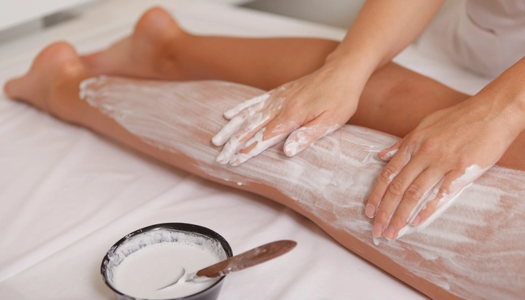 Body wrap treatment being applied to nourish and hydrate the skin.