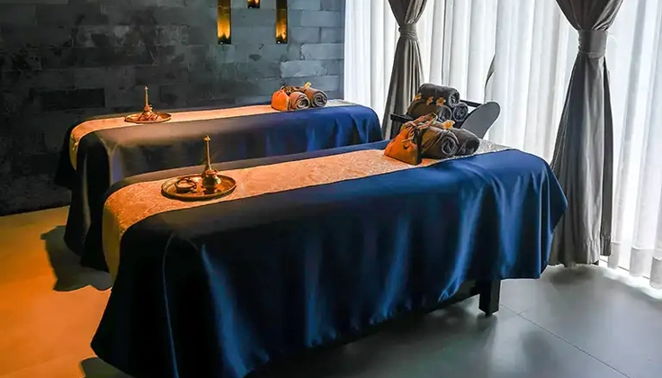 Couple spa room with two massage beds prepared for a relaxing anniversary experience.