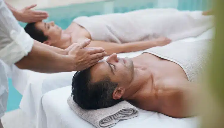 Couple receiving relaxing head massages together during a spa treatment.