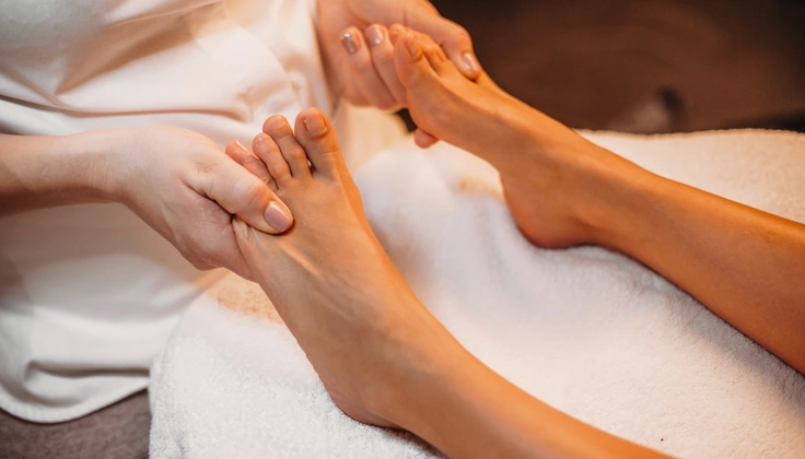 Therapist gently massaging both feet during a relaxing foot massage session.